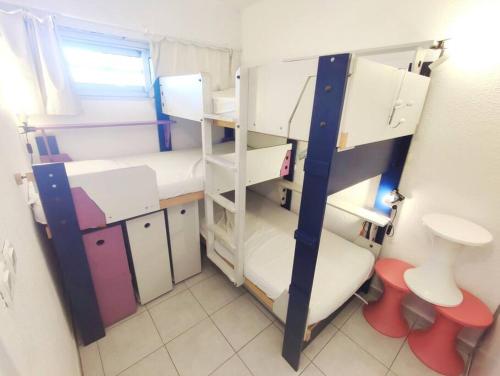Cette petite chambre comprend 2 lits superposés et des toilettes. dans l'établissement T2 au ponant avec piscine, à La Grande Motte