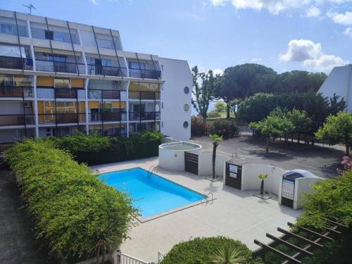 une piscine devant un immeuble dans l'établissement T2 au ponant avec piscine, à La Grande Motte