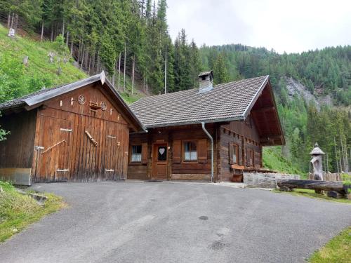a large wooden cabin in the middle of a mountain at Siegel Almhütte in Zederhaus