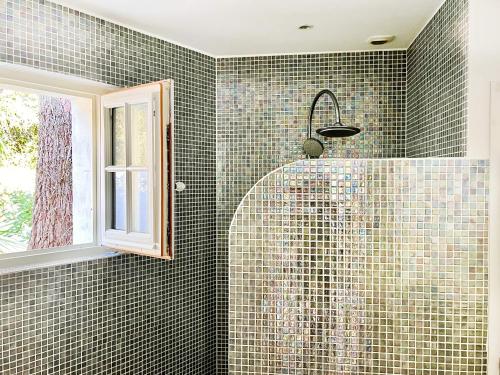 a shower in a bathroom with green tiles at Studio with beautiful private garden on the forest in Domino in Les Sables Vignier