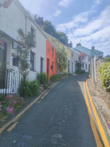 an empty street in a town with colorful houses at Fishermen's cottage with log burner, 2 bathrooms & sea views from garden terraces in The Mumbles