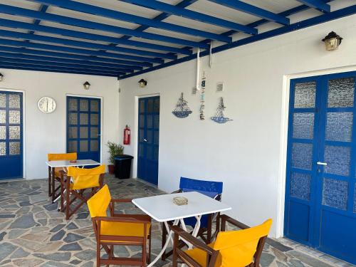 - une salle à manger avec des tables, des chaises et des portes bleues dans l'établissement Antonia, à Galissas