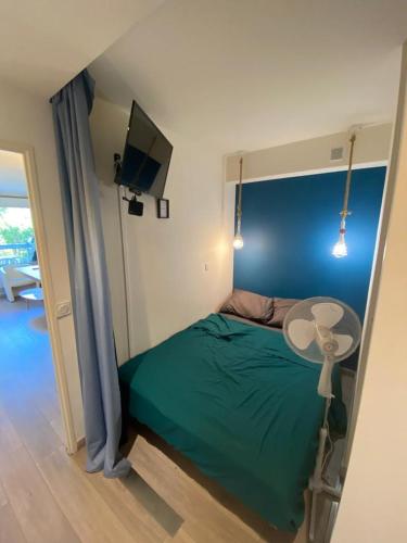 - une petite chambre avec un lit vert et une table dans l'établissement Nice Stay - Charmant 2p climatisé avec piscine et à 8mn des plages, à Antibes