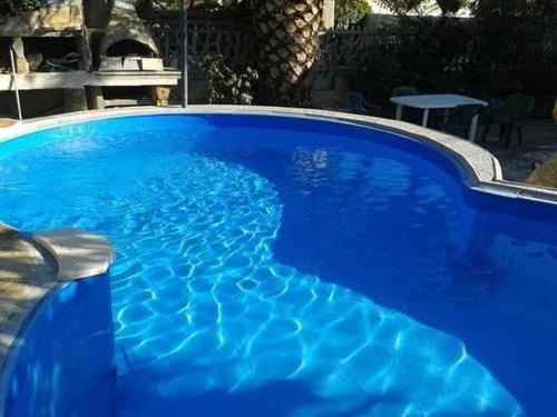 une grande piscine bleue avec de l'eau bleue dans l'établissement Vacanze in Sardegna a Posada, à San Giovanni