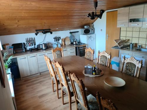 eine Küche mit einem Holztisch und Stühlen in der Unterkunft Pokoje Na Brzegu 