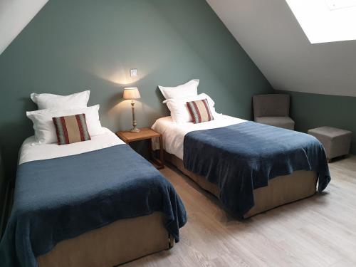 une chambre avec deux lits et une table avec une lampe dans l'établissement Villa Bayeusaine, maison Bayeux Centre Historique - 3 chambres, à Bayeux