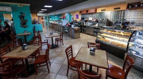 a restaurant with tables and chairs and a bakery at Parador El Buen Cafe in Hatillo