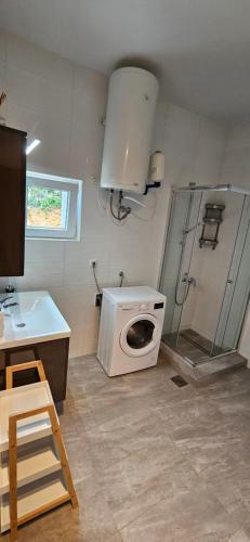 een badkamer met een wasmachine en een douche bij Apartments Vila Zagorje in Stinica