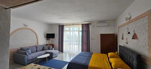 - une chambre avec un lit bleu et un canapé dans l'établissement Apartments Vila Zagorje, à Stinica