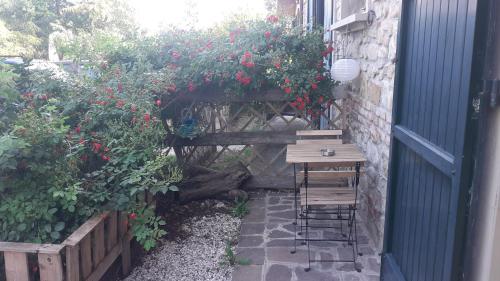 a table and chairs in a garden with red flowers at Ai Boschi in Ozzano dell'Emilia