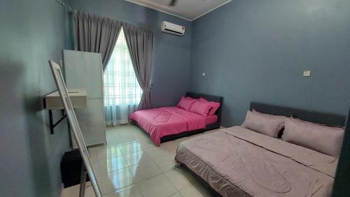 um quarto com 2 camas e uma janela com lençóis cor-de-rosa em Teratak Azhan Homestay em Kampong Sungai Putat