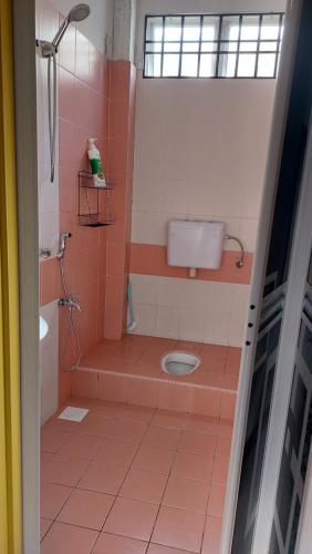a bathroom with a shower and a toilet at Teratak Azhan Homestay in Kampong Sungai Putat
