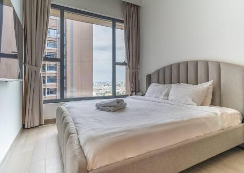 uma cama grande num quarto com uma janela grande em The Rixx Magnificent Apartment @D1/Netflix/bathtub em Ho Chi Minh