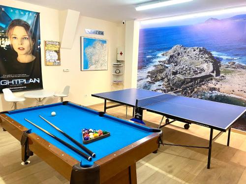 una habitación con 2 mesas de ping pong y una pintura en Casa A Colina en Porto do Son