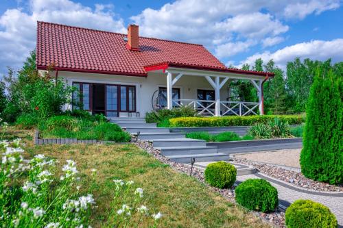 a small house with a red roof at Lakeside Home in Ryn
