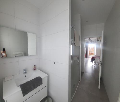 Baño blanco con lavabo y pasillo en Au Gré de L'ill 'Les Cigognes', en Horbourg