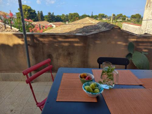 ein blauer Tisch mit einer Schale Obst darauf in der Unterkunft I Macaseni di Franca in Scopello
