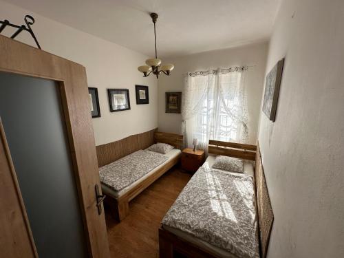 a bedroom with two beds and a window at Apartments & Restaurant Tkalcovsky dvur in Prague