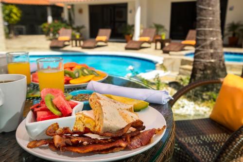 a plate of food on a table next to a pool at Garden By The Sea in Sosúa