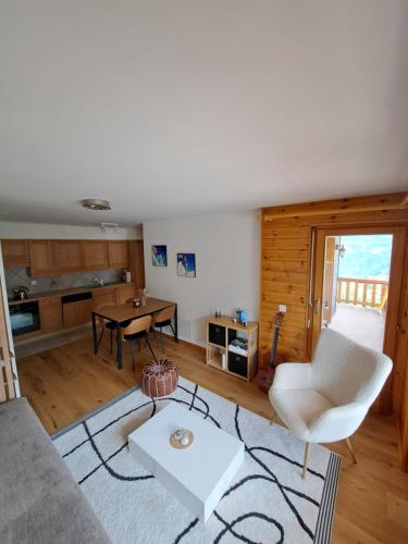 ein Wohnzimmer mit einem Sofa und einem Tisch in der Unterkunft Appartement de charme - Idéal pour un couple in Nendaz