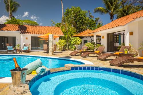 a villa with a swimming pool and a resort at Garden By The Sea in Sosúa
