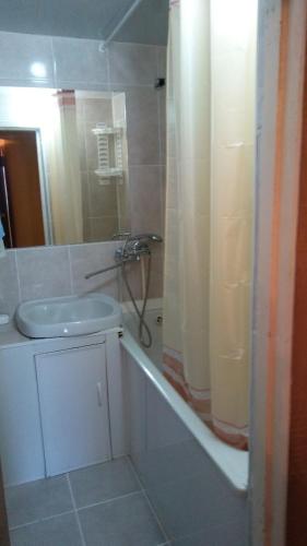 biała łazienka z prysznicem i umywalką w obiekcie Дубоссары ,ул.Ломоносова 8 А w mieście Corjova