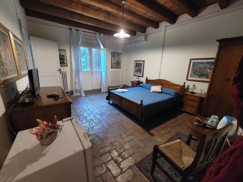 a bedroom with a bed and a living room at Bordeghina B&B In Farmhouse in Pontecchio Polesine