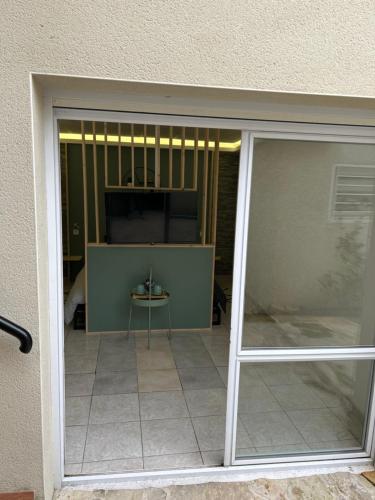 une porte coulissante en verre menant à une terrasse avec une table. dans l'établissement Coconning studio, à Plauzat