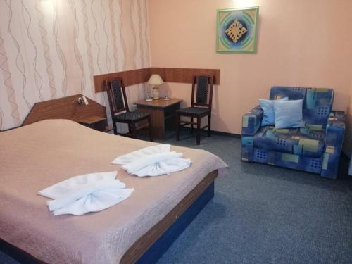 um quarto de hotel com uma cama, uma cadeira e uma mesa em ХОТЕЛ ОМЕГА em Stara Zagora