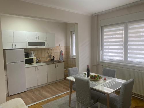 a kitchen and dining room with a table and chairs at Apartment "JONA " in Niš