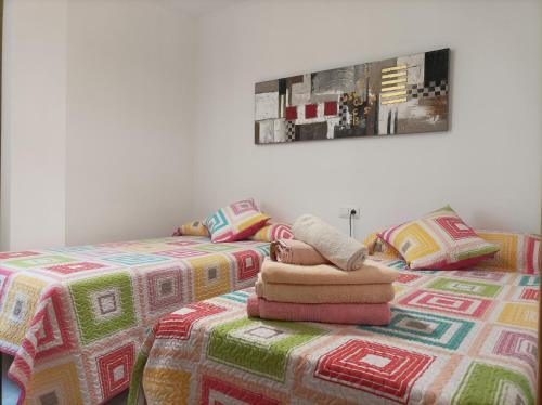 Duas camas com cobertores e almofadas num quarto em Ferrara playa em Torrox Costa