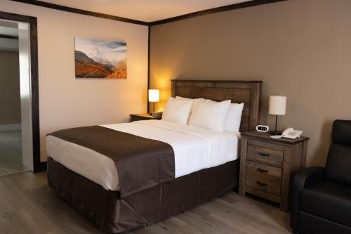 Pokój hotelowy z dużym łóżkiem i krzesłem w obiekcie Motel 7 Inn & Suites w mieście Beresford