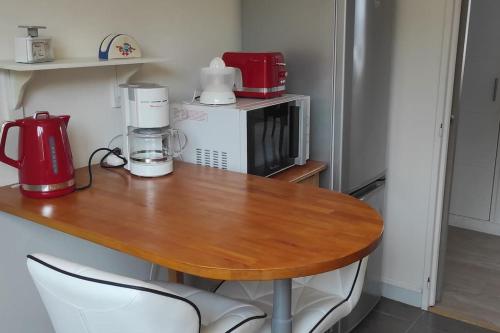 La cuisine est équipée d'une table, d'un four micro-ondes et d'un réfrigérateur. dans l'établissement Appartement T3 confortable et idéalement situé, à Concarneau