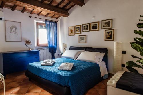 a bedroom with a blue bed with towels on it at Osimo Caves Rooms in Osimo