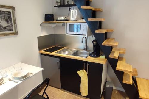 Il comprend une petite cuisine équipée d'un évier et d'un four micro-ondes. dans l'établissement Le Duplex des Halles, à Pau