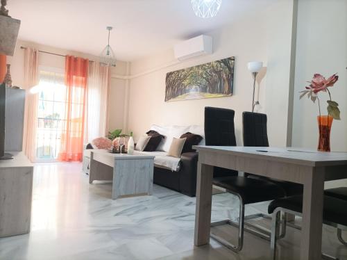 uma sala de estar com uma mesa e um sofá em Ferrara playa em Torrox Costa