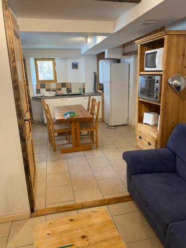 cocina y sala de estar con mesa y sofá en Appartement 4 personnes en Villar-dʼArène