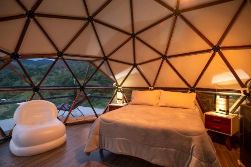 una camera da letto con un letto e una grande finestra di Refugio Mirador del Ocaso a Zipacón