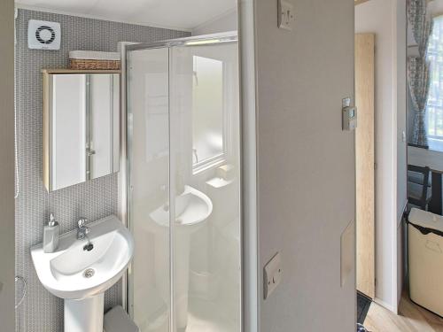 uma casa de banho com um lavatório e uma cabina de duche em vidro. em Long View Lodge em Felton