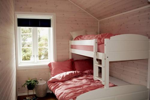 sypialnia z łóżkiem piętrowym i oknem w obiekcie Lille Herstrand - A unique seaside getaway w mieście Meløyskagen