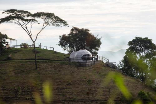a hill with a tent on top of it at Refugio Mirador del Ocaso in Zipacón