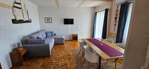 a living room with a table and a couch at Apartments Vila Zagorje in Stinica
