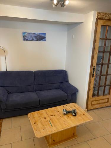 Sala de estar con sofá azul y mesa de centro en Appartement 4 personnes en Villar-dʼArène