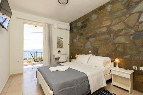 a bedroom with a bed and a stone wall at Αnastasia apartments in Mavrovouni