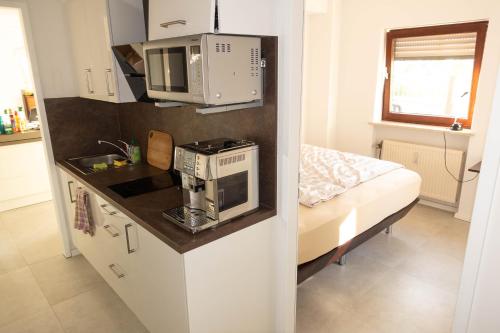 una pequeña cocina con microondas y fregadero en Marc‘s Rooms en Múnich
