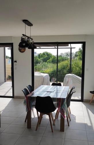a dining table and chairs in a room with a view at maison angles in Angles