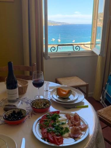 a table with a plate of food and a glass of wine at Menton1974 in Menton