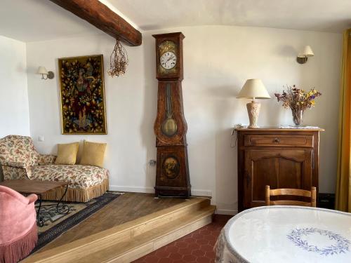 a living room with a grandfather clock and a couch at Menton1974 in Menton