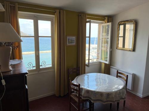 a dining room with a table and two windows at Menton1974 in Menton