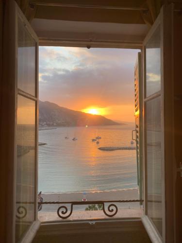 a window with a view of the ocean and the sunset at Menton1974 in Menton